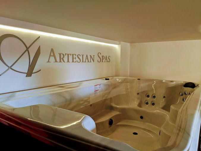 hot tub dealer showroom with artesian spas logo on wall